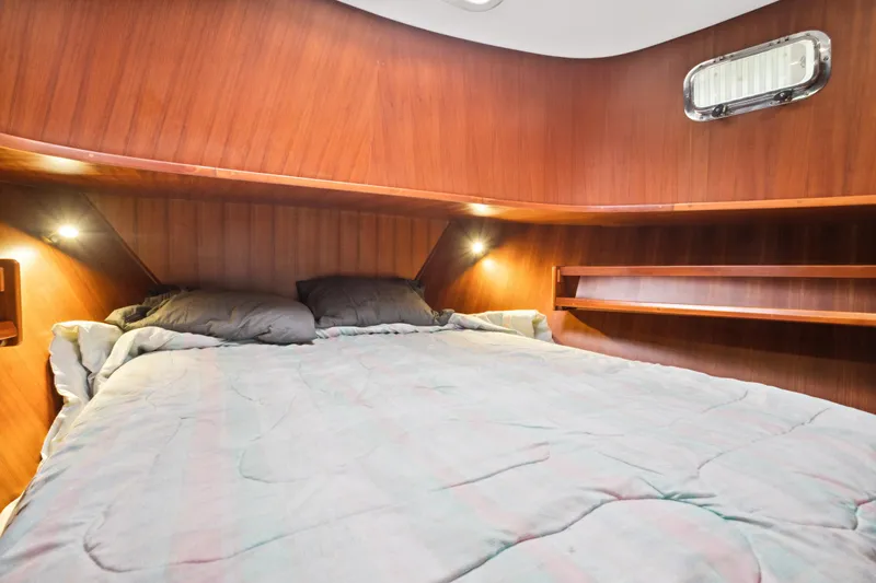 Seabatical Yacht Photos Pics Cozy cabin interior of 2008 North Pacific 43 Pilothouse with wooden walls and comfortable bedding.