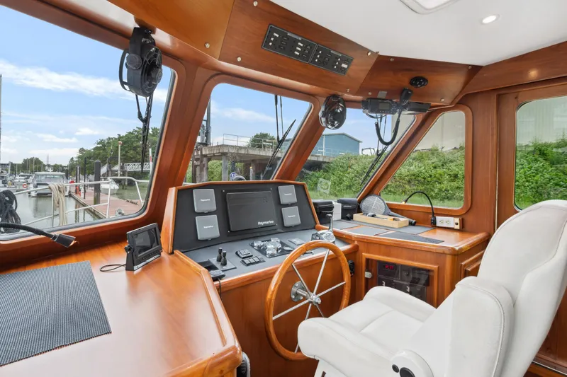Seabatical Yacht Photos Pics Pilothouse interior of 2008 North Pacific 43, featuring navigation equipment and captain's chair.