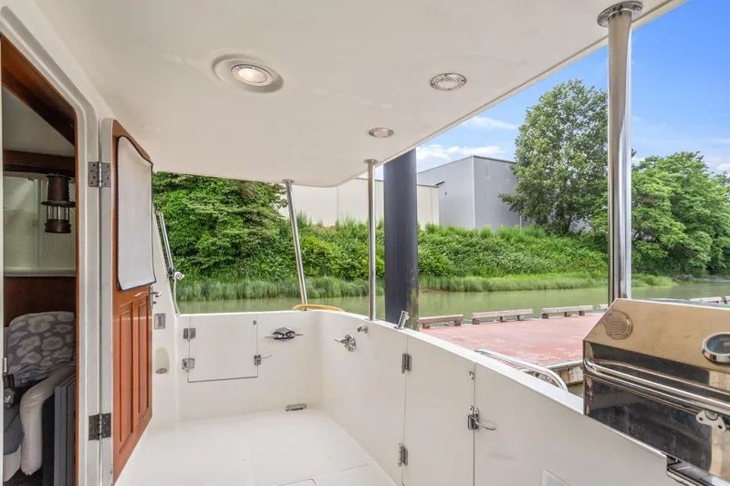 Seabatical Yacht Photos Pics 2008 North Pacific 43 Pilothouse boat deck with outdoor seating and scenic waterfront view.