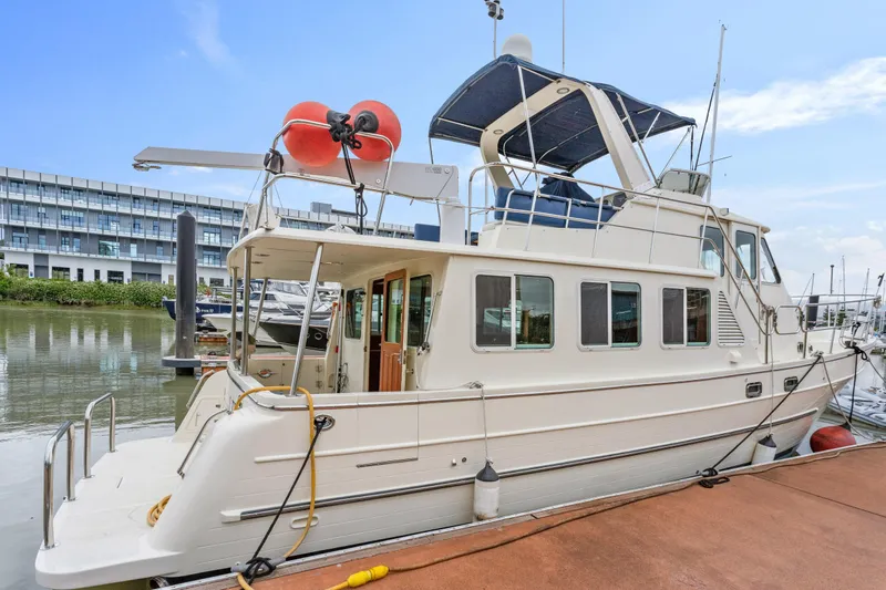 Seabatical Yacht Photos Pics 2008 North Pacific 43 Pilothouse yacht docked at marina, side view.