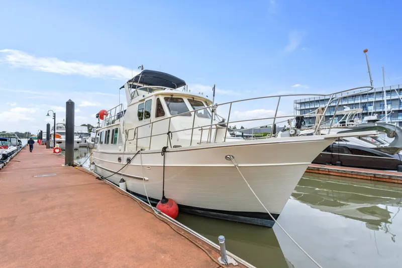 Seabatical Yacht Photos Pics 2008 North Pacific 43 Pilothouse yacht docked at marina under clear blue sky.