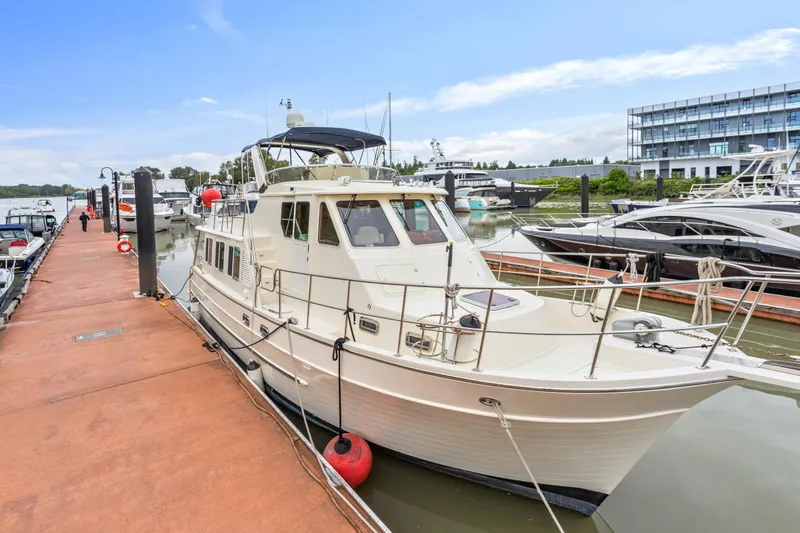 Seabatical Yacht Photos Pics 2008 North Pacific 43 Pilothouse yacht docked at marina, clear sky background.