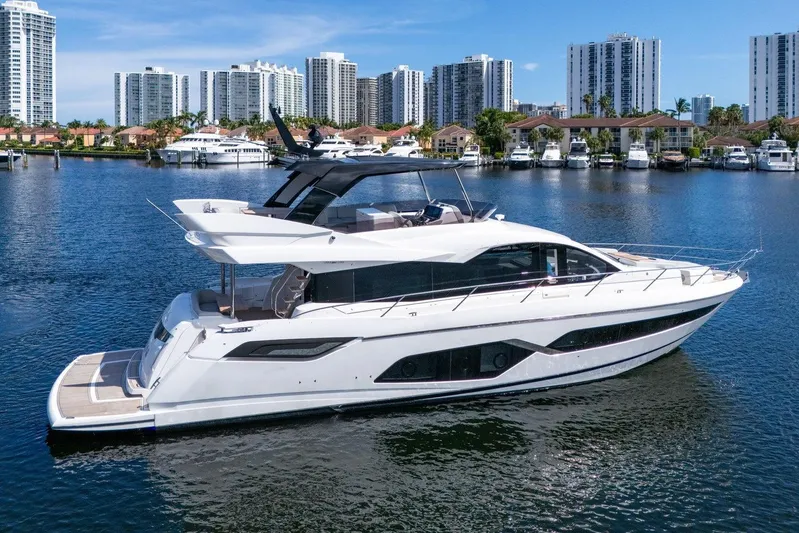 Rani Yacht Photos Pics 2023 Sunseeker Manhattan 68 Pacific yacht on a serene waterfront with city skyline.