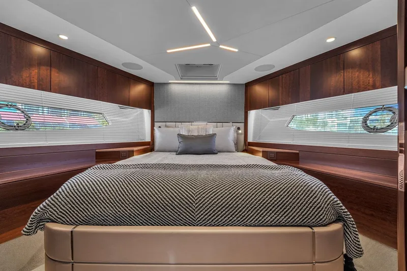 Rani Yacht Photos Pics Luxurious bedroom interior of 2023 Sunseeker Manhattan 68 Pacific yacht, featuring elegant wood finishes.