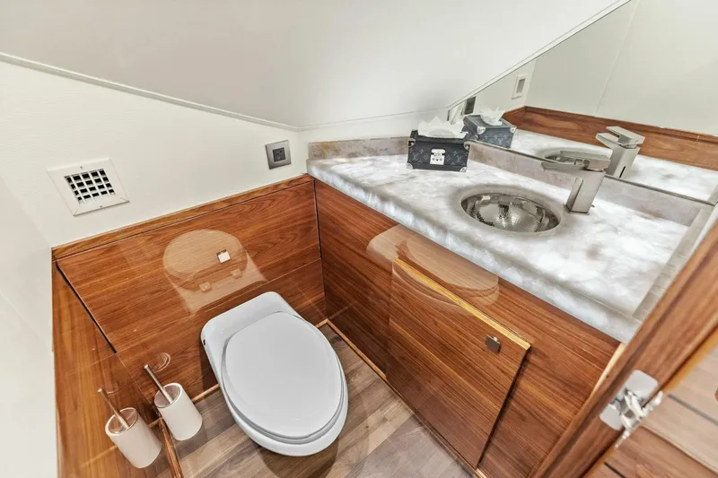 Team Harvey Yacht Photos Pics Luxurious bathroom in 2026 Viking 82 Convertible yacht with wood accents and modern fixtures.