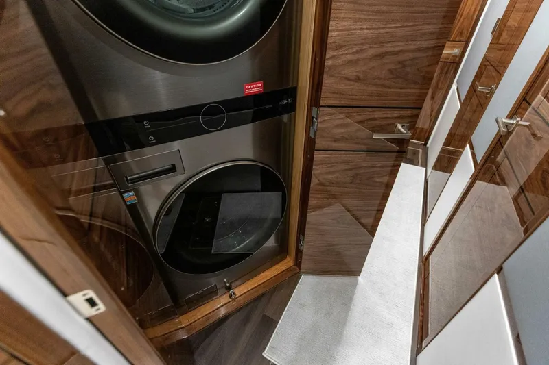 Team Harvey Yacht Photos Pics Laundry area in 2026 Viking 82 Convertible yacht with modern appliances and wood paneling.