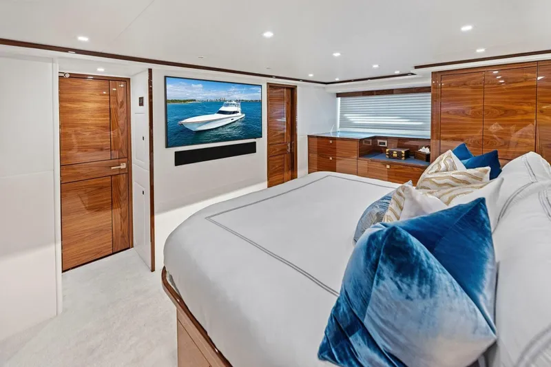 Team Harvey Yacht Photos Pics Luxurious interior of 2026 Viking 82 Convertible yacht with elegant wood finishes and plush bedding.
