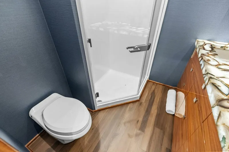 Team Harvey Yacht Photos Pics Bathroom interior of 2026 Viking 82 Convertible yacht with modern fixtures and wood flooring.