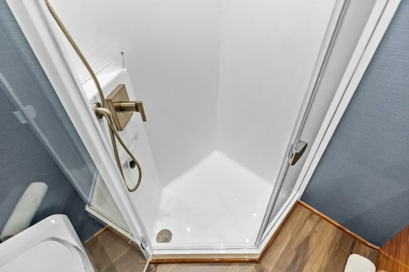 Team Harvey Yacht Photos Pics Shower area in 2026 Viking 82 Convertible yacht with modern fixtures and wooden flooring.