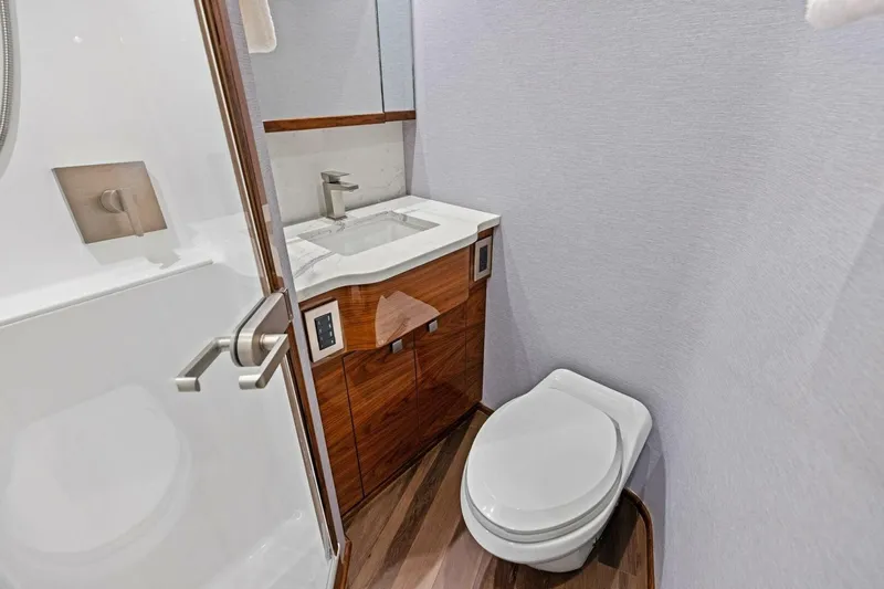 Team Harvey Yacht Photos Pics Luxurious bathroom in 2026 Viking 82 Convertible yacht with modern fixtures and wooden cabinetry.