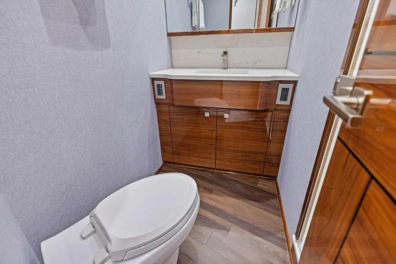 Team Harvey Yacht Photos Pics Luxurious bathroom in 2026 Viking 82 Convertible yacht with modern fixtures and wooden cabinetry.