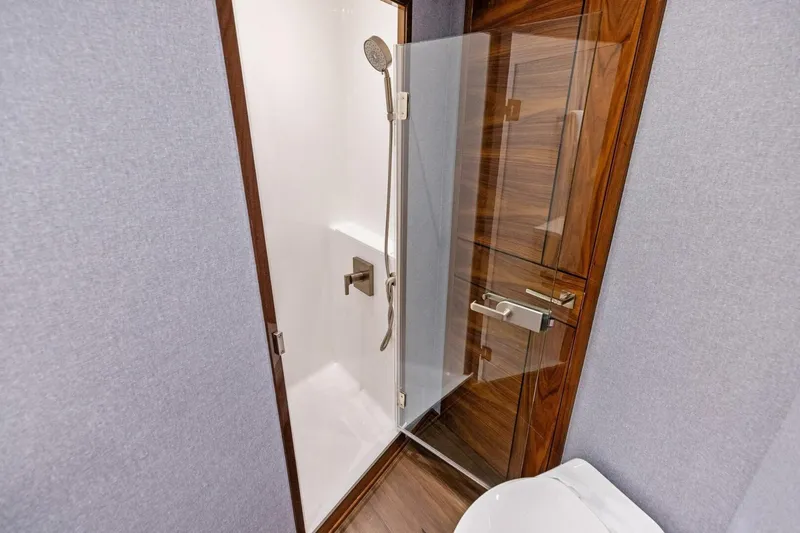 Team Harvey Yacht Photos Pics Luxurious bathroom in 2026 Viking 82 Convertible yacht with modern shower and wooden accents.