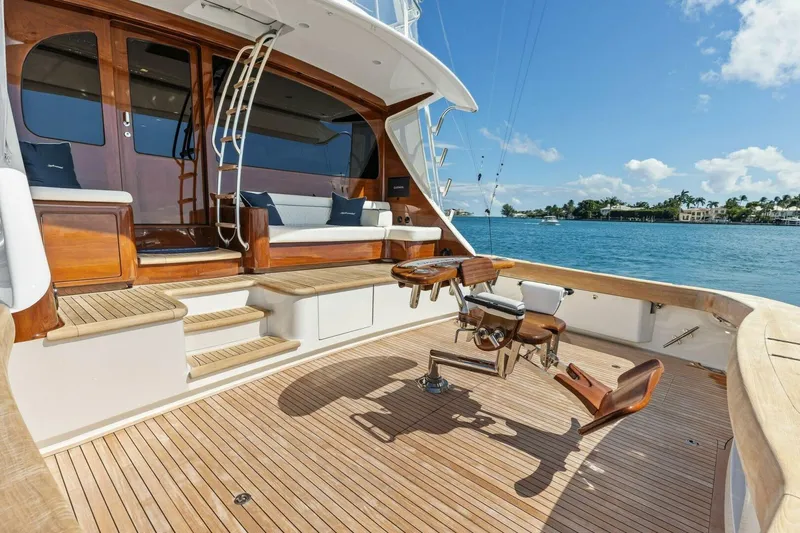 Team Harvey Yacht Photos Pics Luxurious 2026 Viking 82 Convertible yacht deck with fishing chair, overlooking serene waters.