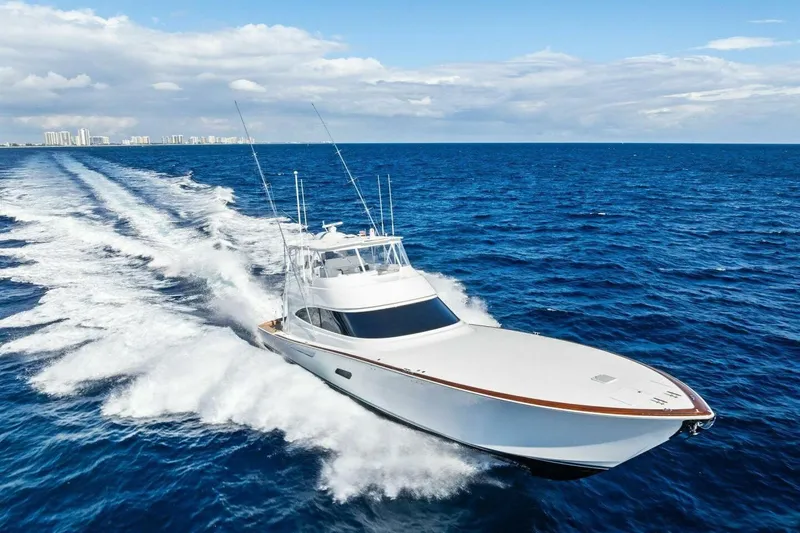 Team Harvey Yacht Photos Pics 2026 Viking 82 Convertible yacht cruising on open ocean with city skyline in background.