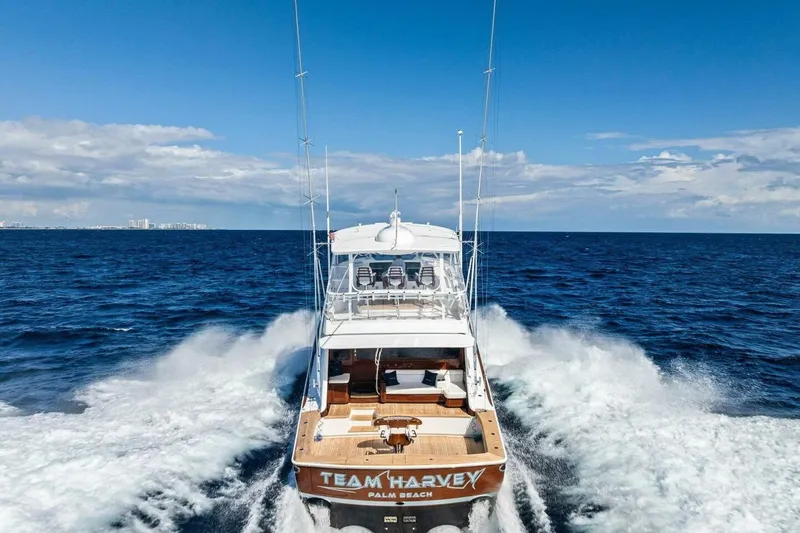 Team Harvey Yacht Photos Pics 2026 Viking 82 Convertible yacht cruising on open ocean, rear view.