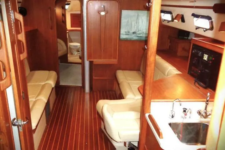 Epithelios Yacht Photos Pics Interior of 2002 Island Packet 420 sailboat with wood finish and beige seating.