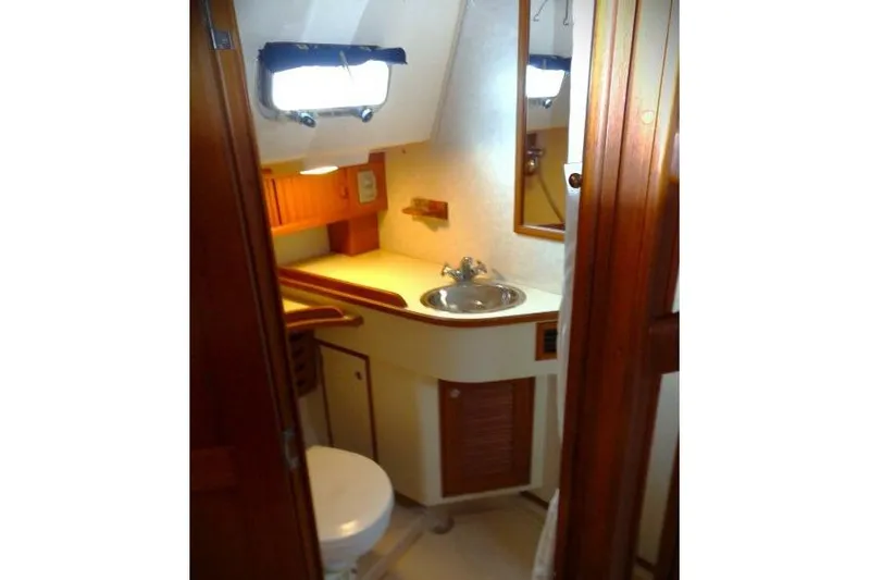 Epithelios Yacht Photos Pics Island Packet 420 yacht bathroom interior, featuring sink, mirror, and wooden cabinetry, 2002 model.