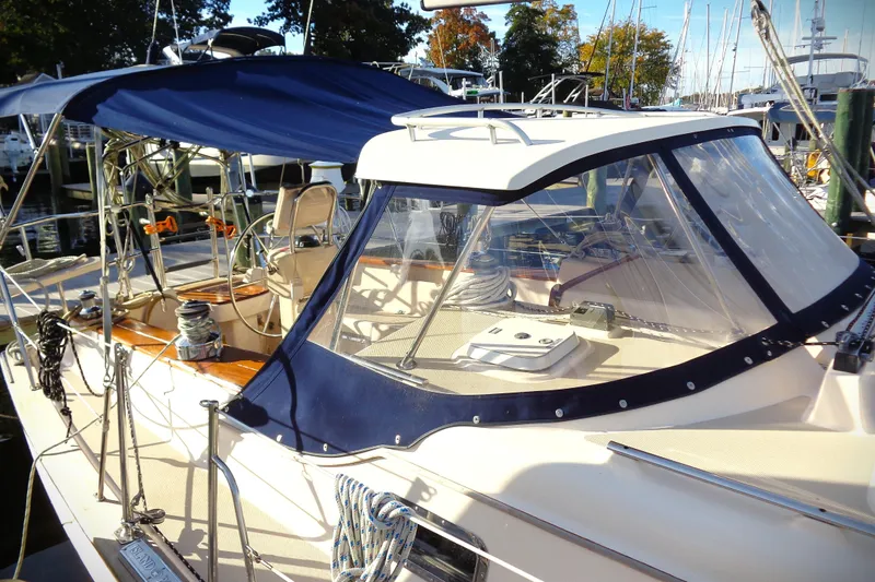 Epithelios Yacht Photos Pics 2002 Island Packet 420 sailboat with blue canopy and clear enclosure at marina.