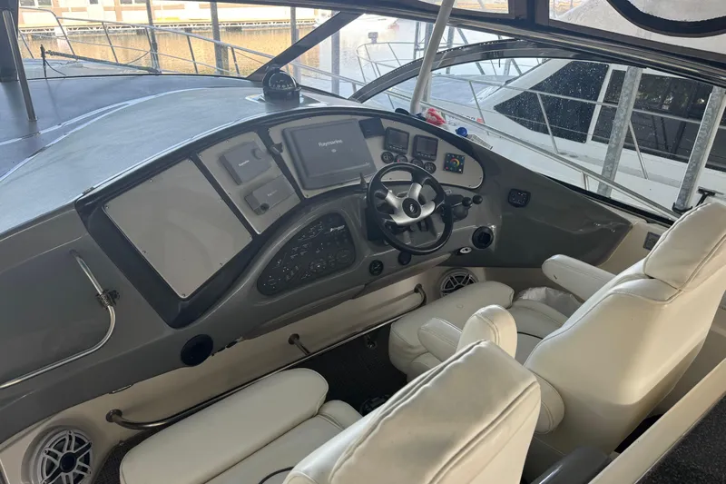  Yacht Photos Pics 2006 Cruisers Yachts 560 Express helm with modern controls and white seating.