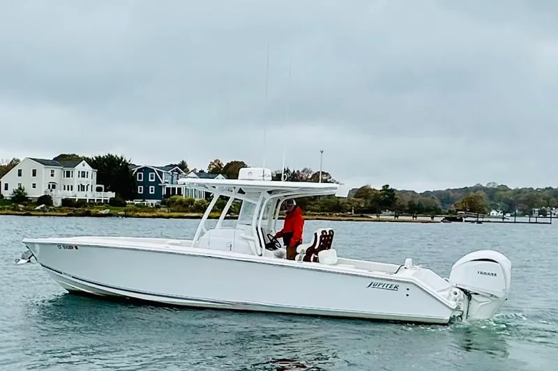 Changes In Lattitudes Yacht Photos Pics 2023 Jupiter 30 boat cruising on a calm lake near waterfront homes.