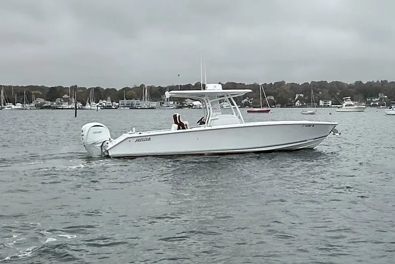 Changes In Lattitudes Yacht Photos Pics 2023 Jupiter 30 boat cruising on a cloudy day in a marina.