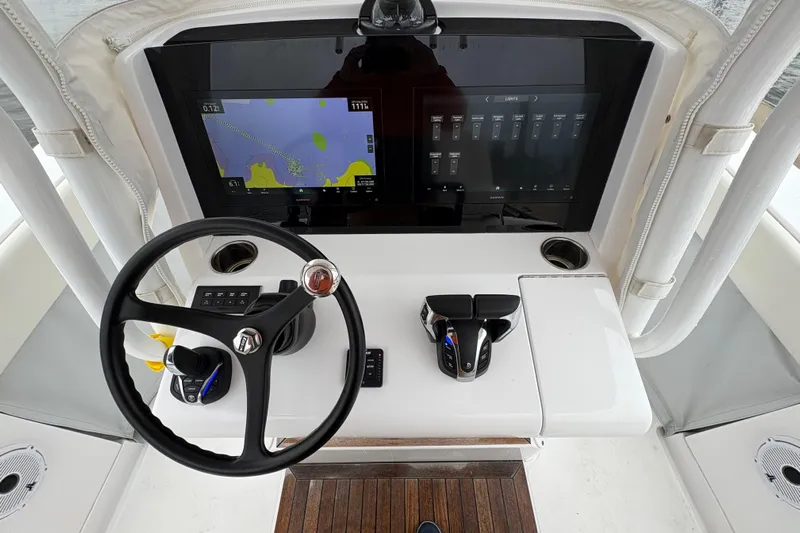 Changes In Lattitudes Yacht Photos Pics 2023 Jupiter 30 boat helm with steering wheel, navigation screens, and controls.