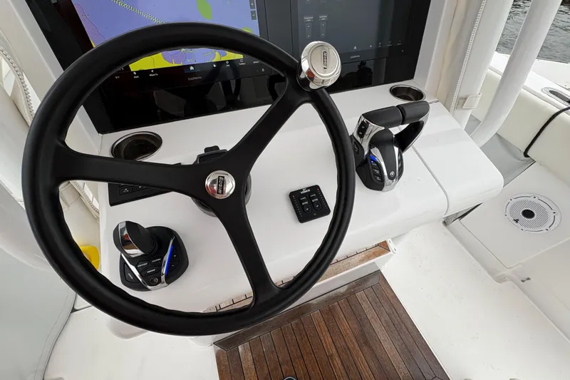 Changes In Lattitudes Yacht Photos Pics Steering wheel and controls of 2023 Jupiter 30 boat, featuring modern navigation display.