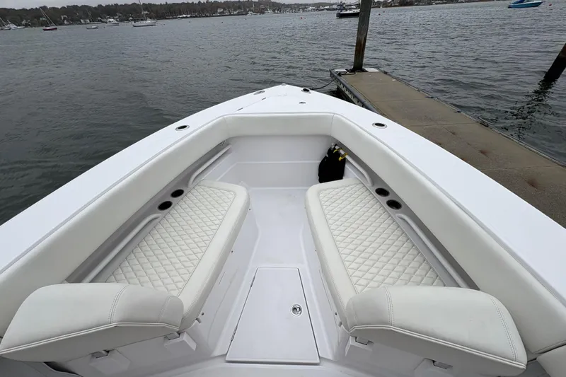 Changes In Lattitudes Yacht Photos Pics 2023 Jupiter 30 boat with white quilted seating, docked by the water.