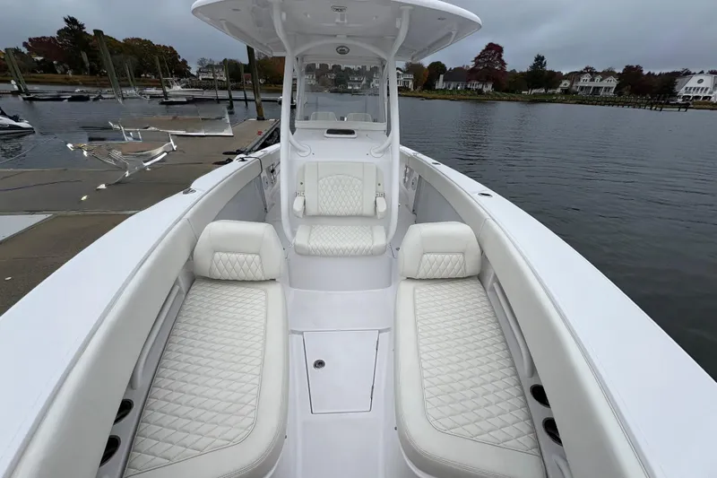 Changes In Lattitudes Yacht Photos Pics 2023 Jupiter 30 boat with luxurious white seating, docked by a serene waterfront.