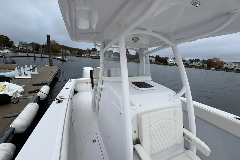 Changes In Lattitudes Yacht Photos Pics 2023 Jupiter 30 boat docked by waterfront homes on a cloudy day.