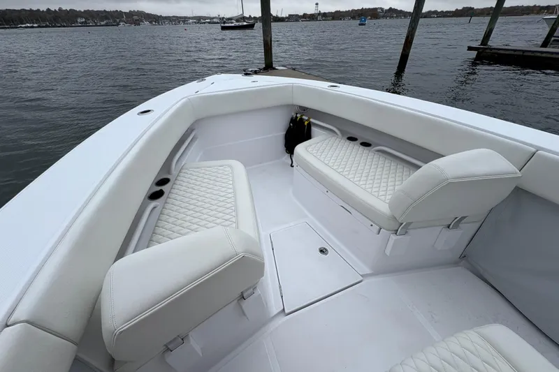 Changes In Lattitudes Yacht Photos Pics 2023 Jupiter 30 boat interior with white seating, docked by the water.