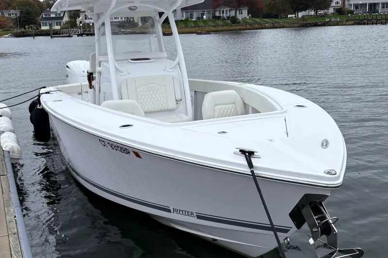 Changes In Lattitudes Yacht Photos Pics 2023 Jupiter 30 boat docked on calm water, featuring sleek design and white seating.