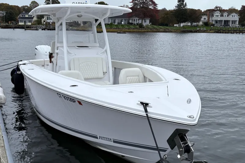 Changes In Lattitudes Yacht Photos Pics 2023 Jupiter 30 boat docked on a calm waterfront with houses in the background.