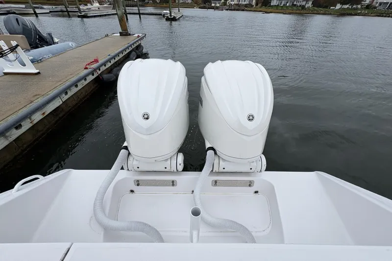 Changes In Lattitudes Yacht Photos Pics Twin outboard engines on a 2023 Jupiter 30 boat docked by the water.