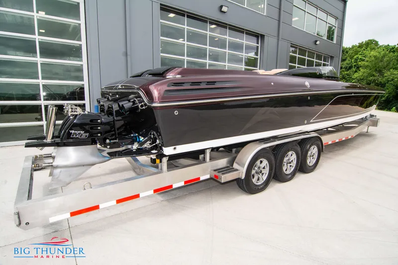  Yacht Photos Pics 2020 Donzi 38 ZRC powerboat on a triple-axle trailer outside a modern building.