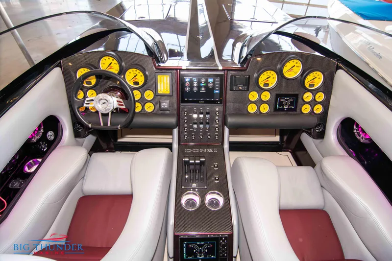  Yacht Photos Pics Cockpit of a 2020 Donzi 38 ZRC speedboat with dual steering wheels and yellow gauges.