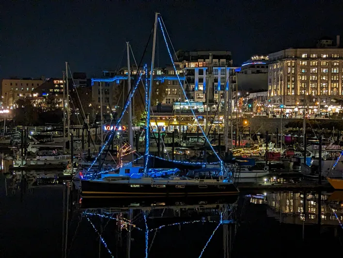 Foxy Yacht Photos Pics Sundeer 56 sailboat illuminated with blue lights at night in a vibrant marina, 1995 model.