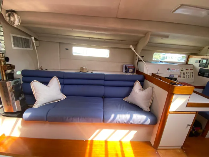 Foxy Yacht Photos Pics Interior of a 1995 Sundeer 56 yacht with blue seating and white pillows.