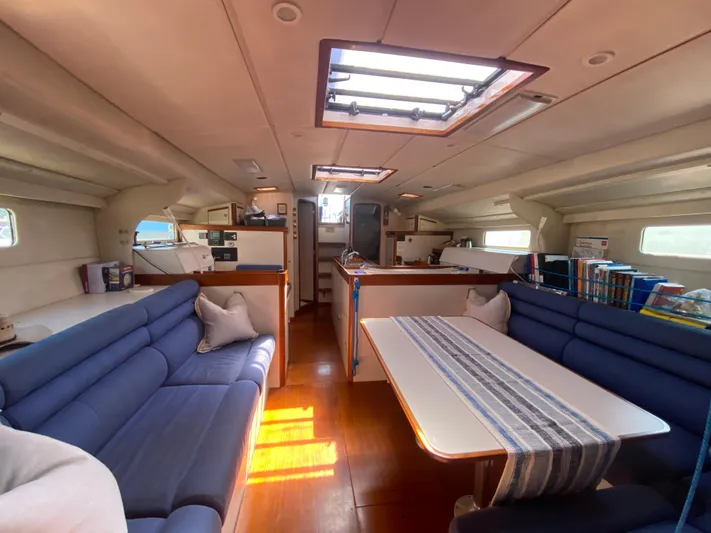 Foxy Yacht Photos Pics Spacious interior of a 1995 Sundeer 56 yacht with blue seating and a dining table.