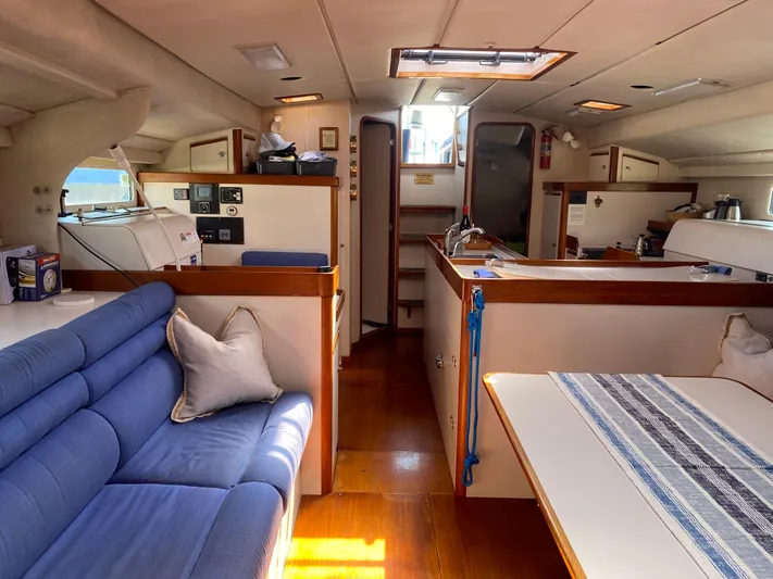Foxy Yacht Photos Pics Interior of a 1995 Sundeer 56 yacht with blue seating and wooden accents.