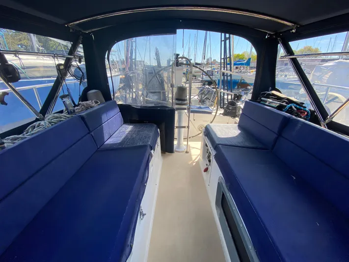 Foxy Yacht Photos Pics Interior view of a 1995 Sundeer 56 sailboat with blue seating and marina background.