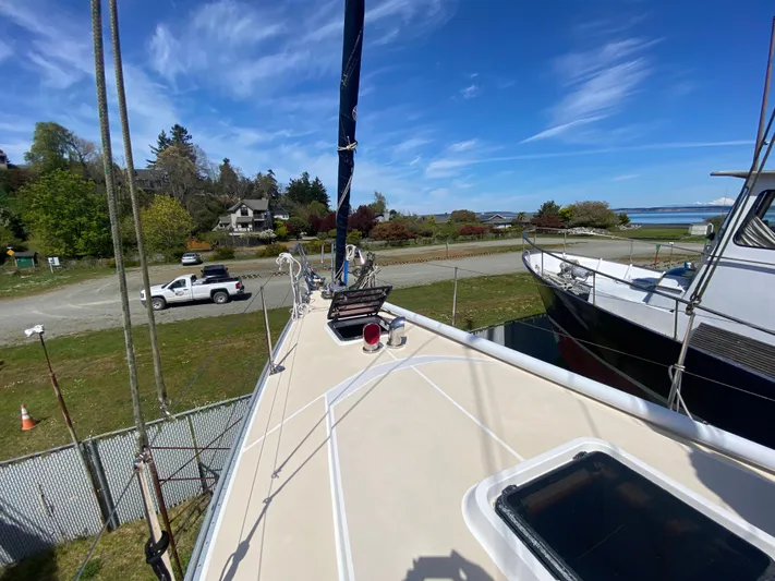 Foxy Yacht Photos Pics Sundeer 56 sailboat deck, 1995 model, docked with scenic coastal background.