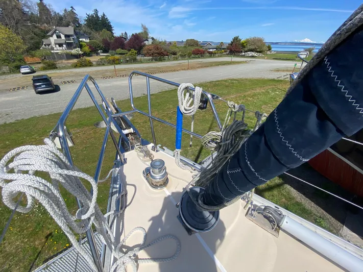 Foxy Yacht Photos Pics Sundeer 56 sailboat deck, 1995 model, with ropes and winch, near coastal landscape.