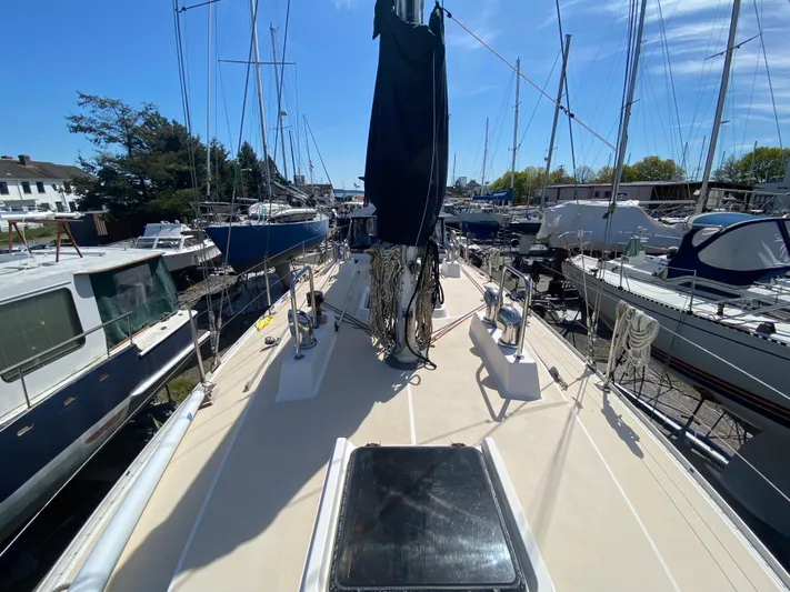 Foxy Yacht Photos Pics Sundeer 56 sailboat deck, 1995 model, docked among other boats under clear blue sky.