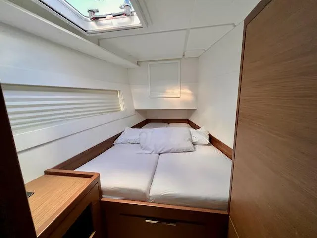 Queen Mary II Yacht Photos Pics Cozy cabin interior of 2019 Lagoon 40 catamaran with skylight and wooden accents.