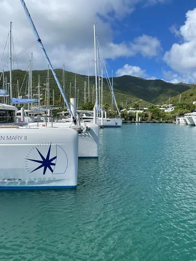 Queen Mary II Yacht Photos Pics 2019 Lagoon 40 catamaran docked in a scenic marina with lush hills.