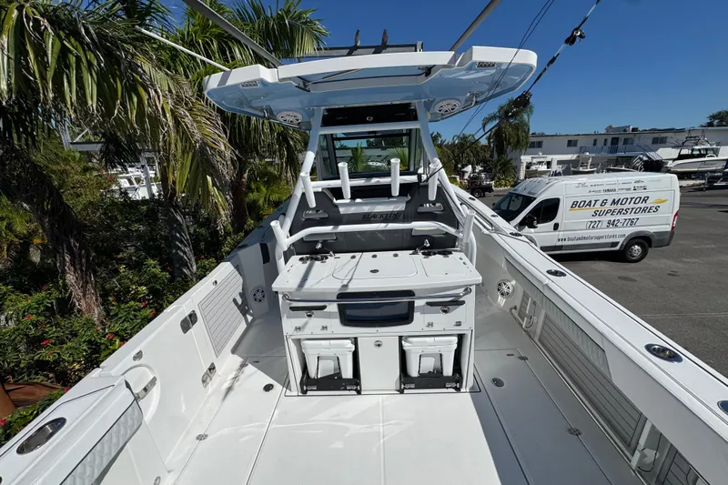  Yacht Photos Pics 2021 Blackfin 332 CC boat interior with fishing setup, parked near palm trees and a service van.