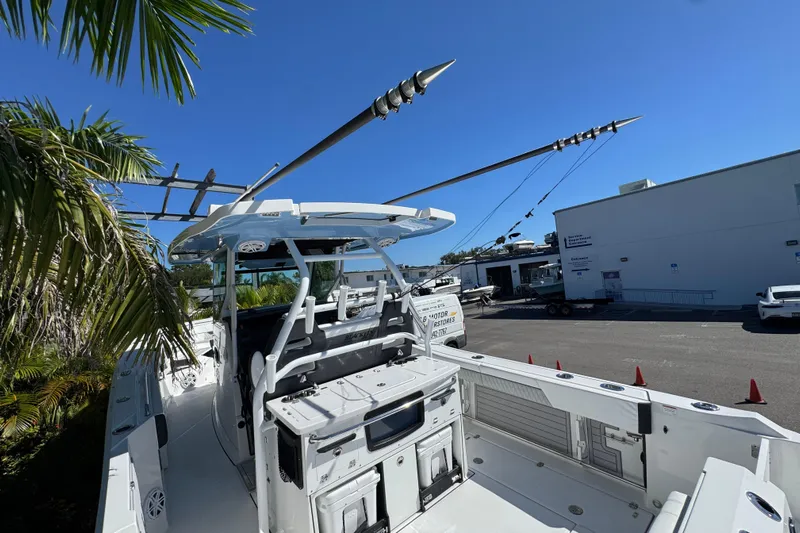  Yacht Photos Pics 2021 Blackfin 332 CC boat docked, surrounded by palm trees and clear blue sky.