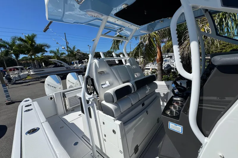  Yacht Photos Pics 2021 Blackfin 332 CC boat interior with seating and console, surrounded by palm trees.