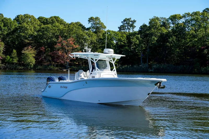  Yacht Photos Pics 2022 Sea Fox 288 Commander boat on a serene lake with lush green trees.